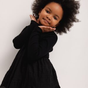 Sukienka rozkloszowana w kolorze Mini sukienka dla dziewczynki wykonana z dwóch rodzajów materiału w kolorze czarnym . Model z długim.